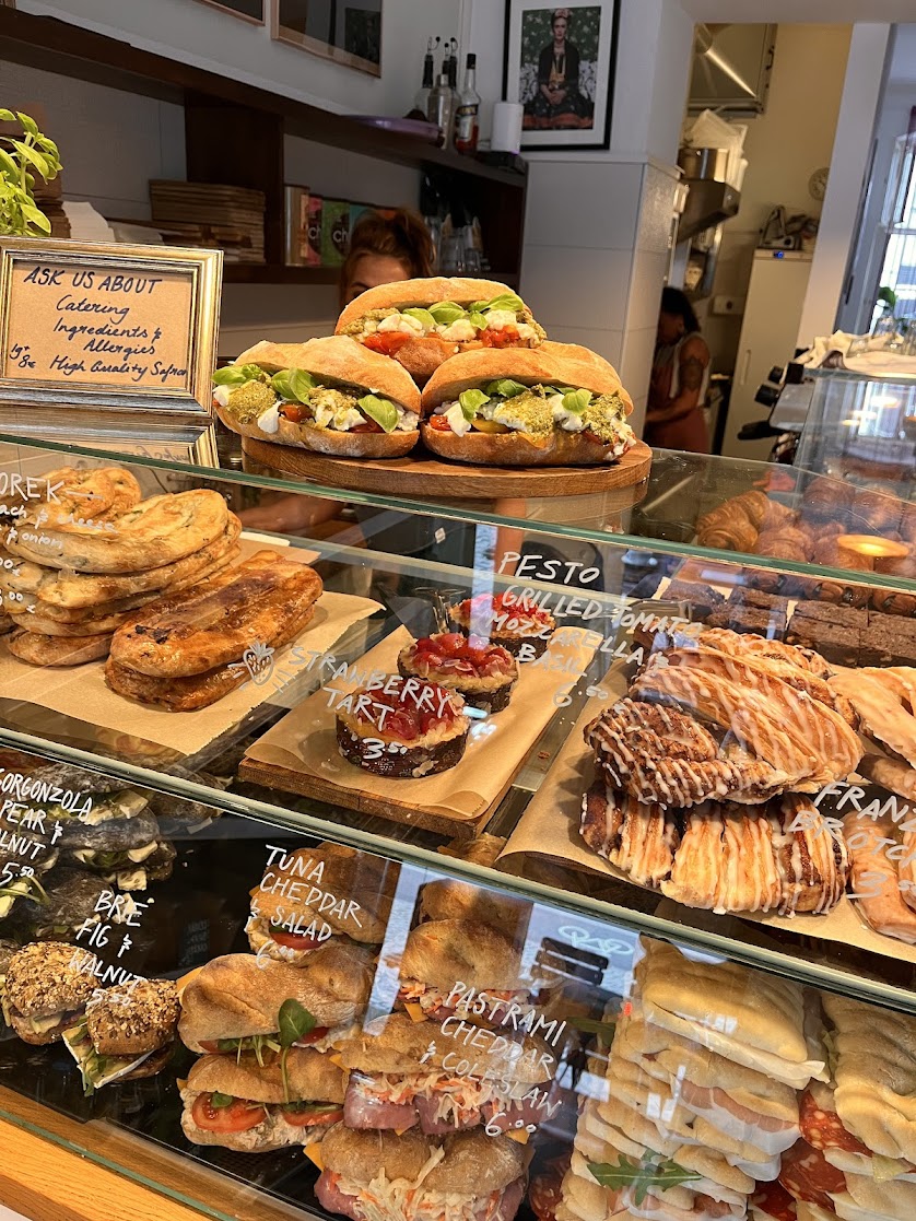 Die Vitrine im Café Frida: Sandwiches, Börek, handgeschriebene Schilder – und das Schild 'Ask us about Catering'