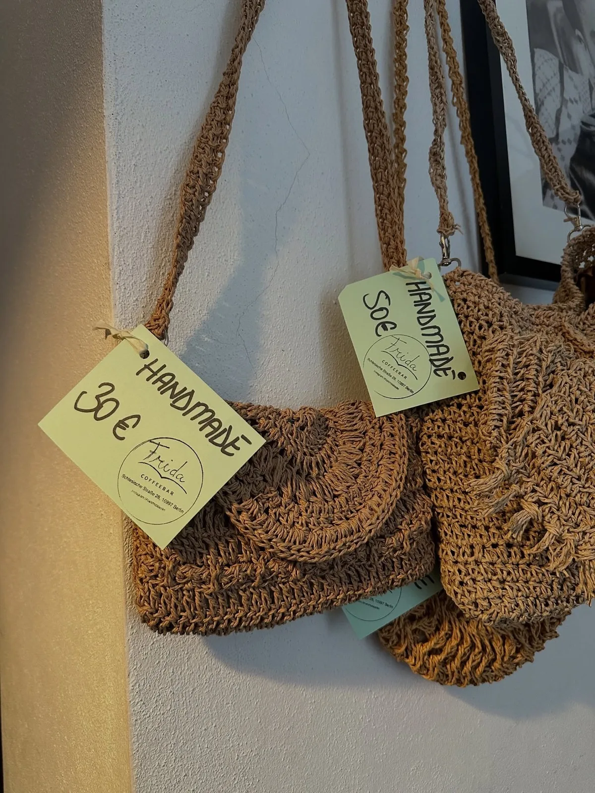 Handgemachte Häkeltaschen mit Preisschildern an der Wand